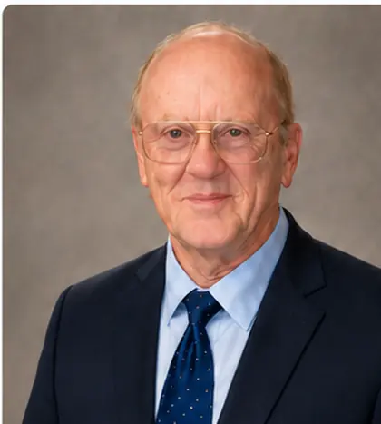 John W. Adcox, Jr. in a navy suit and tie.
